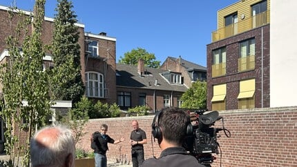 Een cameraploeg die medewerkers van Woonwenz vastlegt op beeld