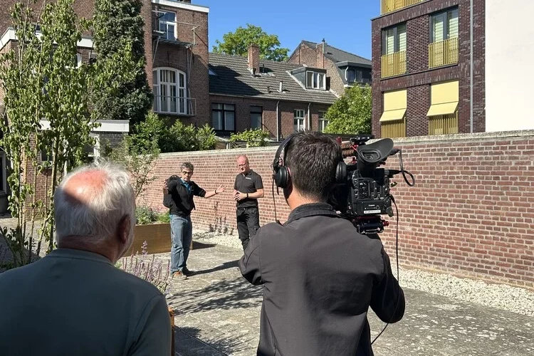 Een cameraploeg die medewerkers van Woonwenz vastlegt op beeld